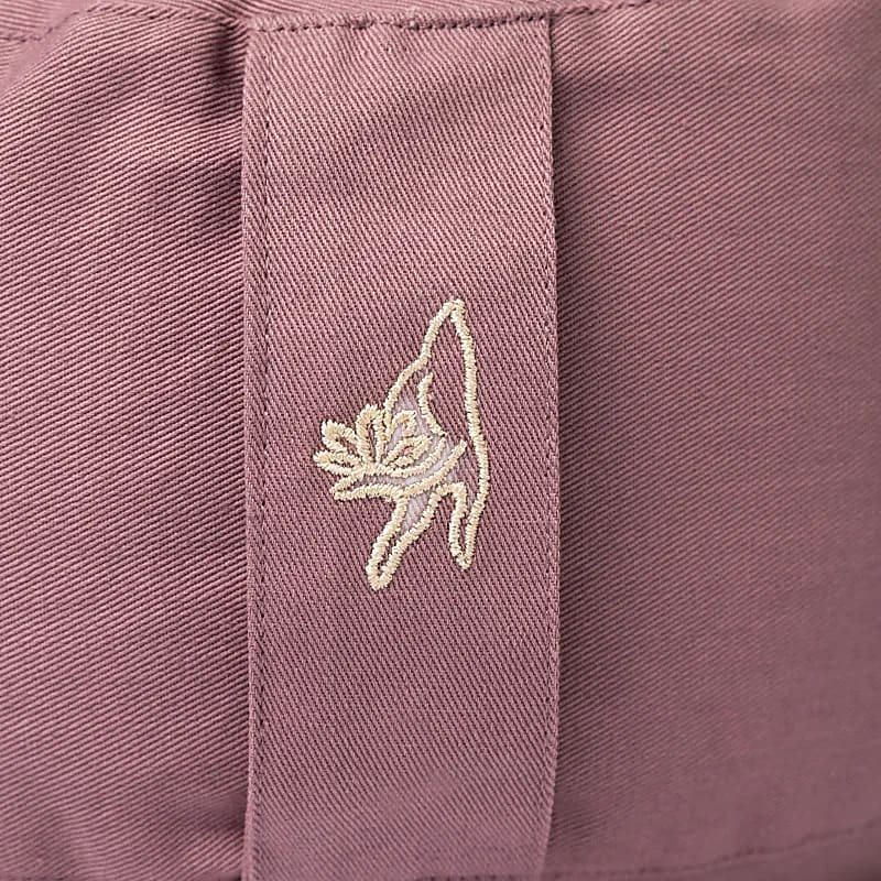 Lila meditatiekussen, detail van het geborduurde logo – vrijstaand